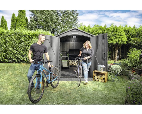 Garten mit Gerätehaus, Fahrrädern und zwei Personen vor geöffneten Türen