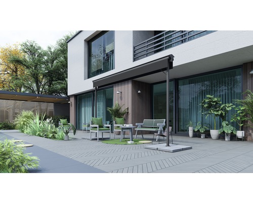 Terrasse avec mobilier, store et plantes devant une maison