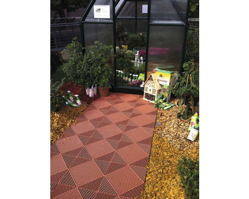 Gewächshaus mit Pflanzen, Insektenhotel und Bodenplatten mit Muster