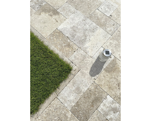 Verlegte Natursteinplatten im Aussenbereich mit Rasenfläche und Solarleuchte