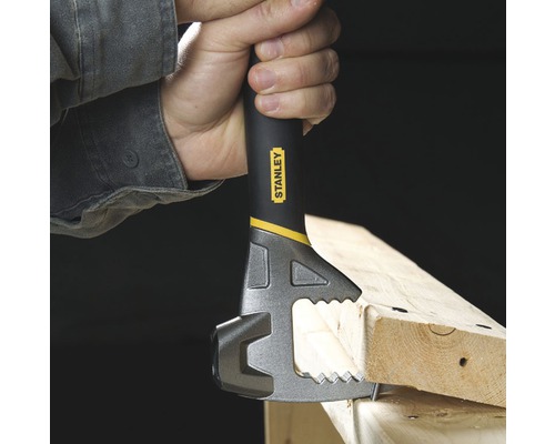 Eine Hand hält einen Stanley Multifunktions-Werkzeugkopf an einem Stück Holz.