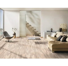 Salon lumineux avec sol stratifié, canapé, fauteuil et escalier