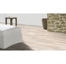 Plancher en bois clair dans un salon avec décoration en pierre et meubles blancs.