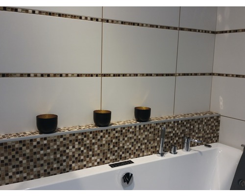 Salle de bains moderne avec carrelage blanc, bordure en mosaïque et baignoire