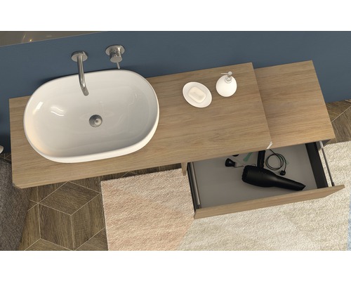 Aufsicht auf ein Badezimmerwaschbecken mit Unterschrank, offenem Schubfach, Seife und Seifenspender.