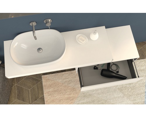 Badezimmer mit Waschbecken, Armatur, Seifenspender, Seife und offenem Schubfach mit Haartrockner.