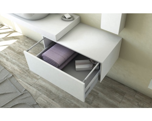 Weisser Waschtischunterschrank mit offener Schublade, gefüllt mit Handtüchern und einer Geschenkbox