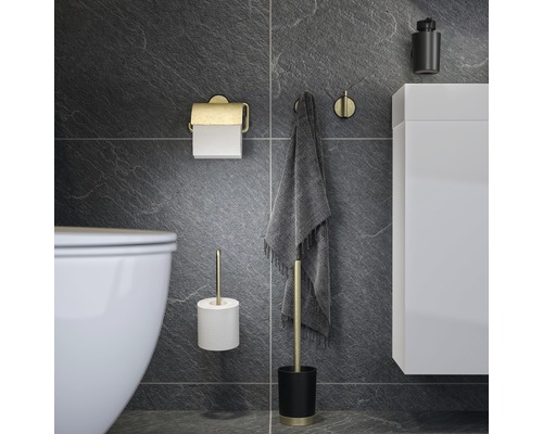 Scène de salle de bains avec porte-papier toilette, porte-serviettes, brosse de toilette et meuble sous-lavabo