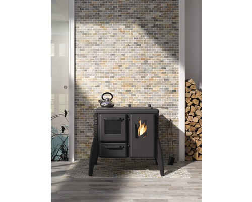 Photo d''intérieur avec un fourneau, une bouilloire, du bois de chauffage et un mur en briques