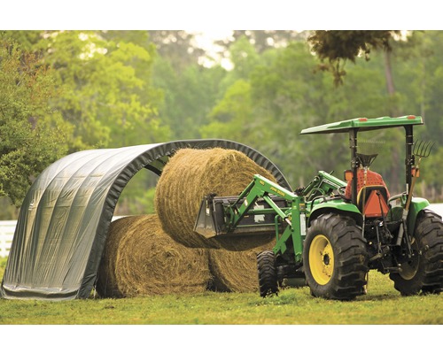 Landwirtschaftliche Szene mit Traktor, Heuballen und Unterstand für Heuballen