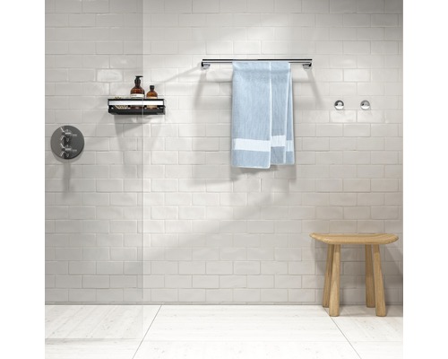 Modernes Badezimmer mit Handtuch, Handtuchhalter, Ablage und Hocker.