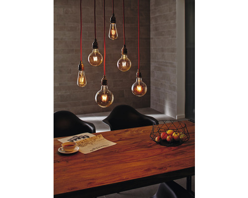 Esszimmer mit Holztisch, Stühlen und hängenden Glühbirnenleuchten