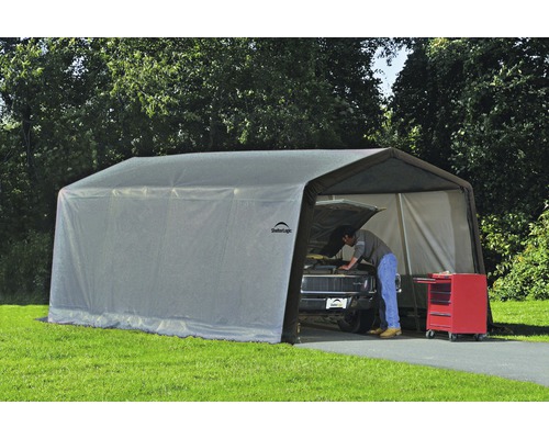 Tente de stockage ShelterLogic montée avec une personne travaillant sur une voiture