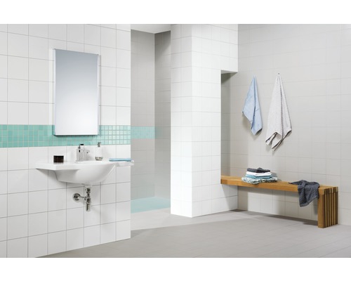 Salle de bain lumineuse avec lavabo, miroir, carrelage et banc en bois