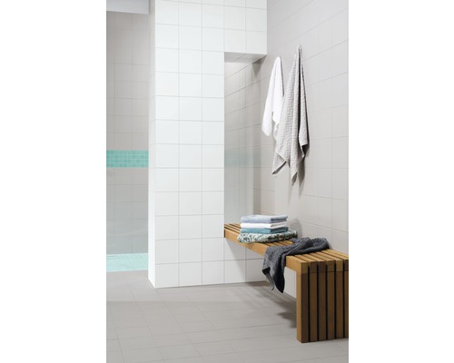 Espace douche carrelé avec bancs en bois et serviettes