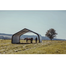 Pferdeunterstand auf einer Wiese mit zwei Pferden und zwei Personen