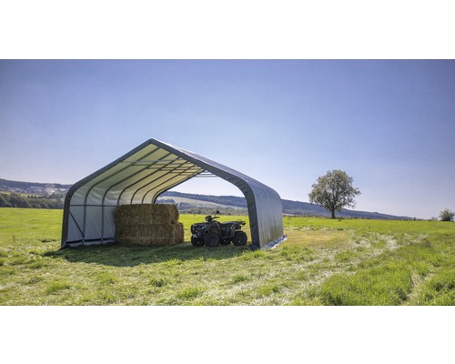 Stahlrohrhalle mit Heuballen und Quad auf einer Wiese