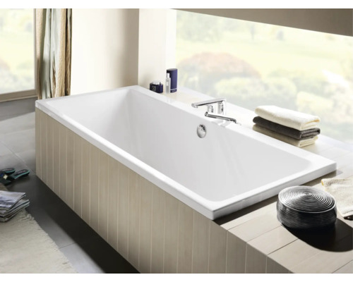 Baignoire rectangulaire dans une salle de bains avec robinetterie et serviettes