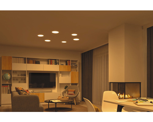 Salon avec spots encastrés, bibliothèque, télévision et cheminée