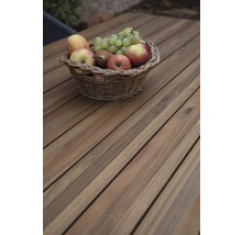 Panier avec pommes, poires et raisins sur une table en bois