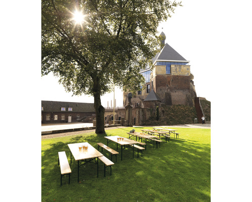 Scène de jardin de bière avec tables et bancs en bois sur une pelouse devant un château