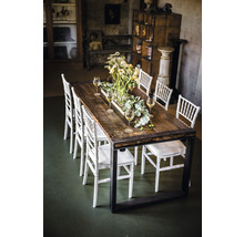 Table de salle à manger avec plateau en bois, structure en métal, chaises et décoration de table dans une pièce