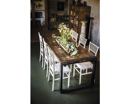 Table de salle à manger avec plateau en bois, structure en métal, chaises et décoration de table dans une pièce