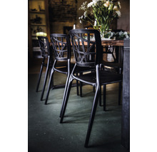 Plusieurs chaises noires autour d''une table à manger au design moderne.