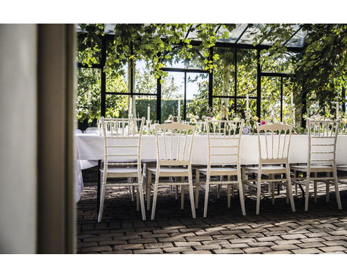 Table dressée avec des chaises dans un jardin d''hiver