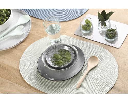 Tischdekoration mit Tellern, Schüsseln, Besteck und Gläsern auf Tischsets