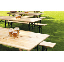 Mehrere Biertischgarnituren auf einer Wiese mit Bierkrügen