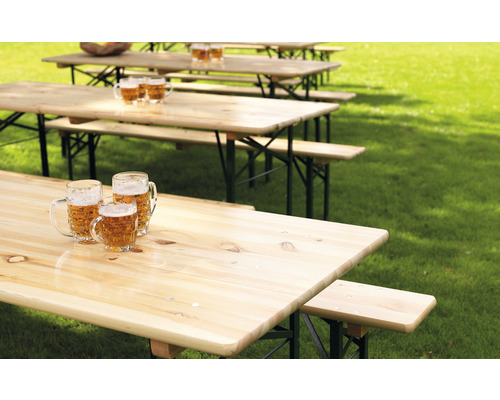 Plusieurs ensembles de tables de bière dans une prairie avec des chopes de bière