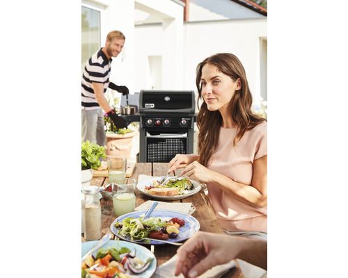 Szene mit Weber Grill, Esstisch und Personen im Freien