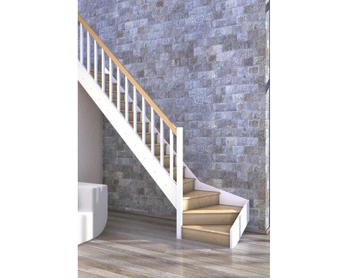 Escalier avec marches en bois et rampe blanche devant un mur en pierre