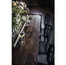 Table de salle à manger en bois avec décorations florales, verres et chaises