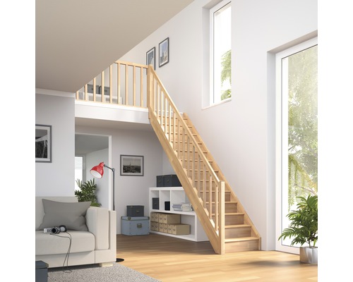 Escalier en bois clair dans un espace de vie moderne avec de hauts plafonds et de grandes fenêtres.