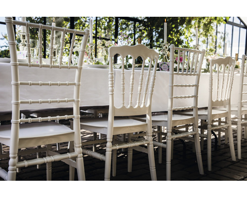 Rangée de chaises blanches à une table dressée