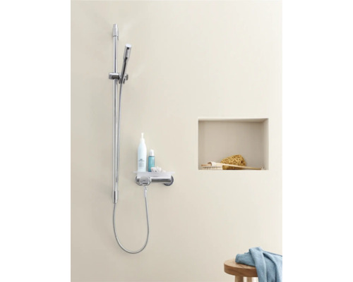 Ensemble de douche avec étagère et accessoires de douche dans une salle de bains lumineuse