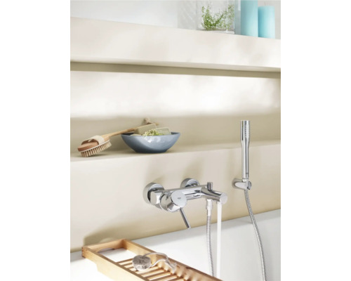 Aufnahme eines Badezimmers mit Armatur, Handbrause, Seife, Bürste und Holzablage