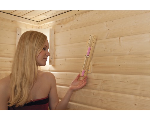 Frau in Sauna mit Sanduhr zur Zeitmessung