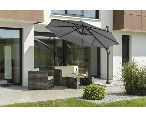 Scène avec un parasol déporté et un salon de jardin sur une terrasse.