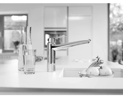 Scène de cuisine avec robinet d''évier, verre et carafe