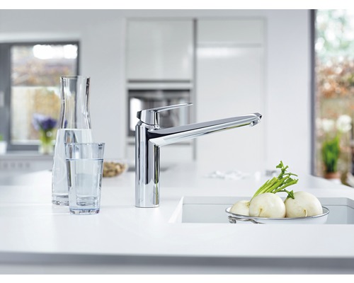 Cuisine moderne avec robinet d''évier, carafe, verre et légumes