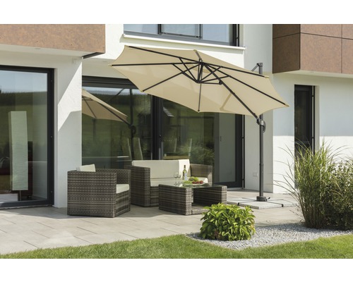 Scène de jardin avec parasol déporté, salon de jardin en rotin et table à manger sur une terrasse