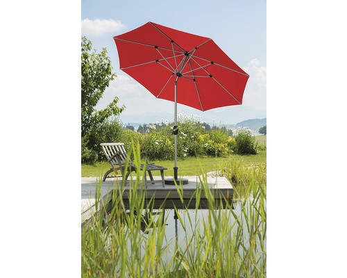 Parasol rouge avec chaise longue en bois dans le jardin au bord de l''étang
