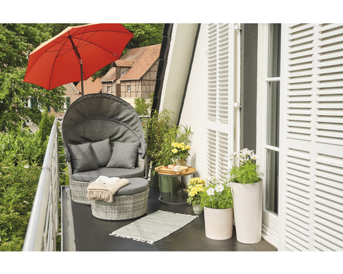 Balcon avec fauteuil lounge, parasol et pots de fleurs