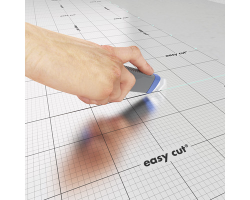 Main coupant avec un couteau à tapis sur un tapis de coupe avec grille