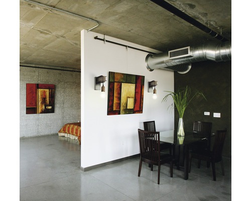 Innenaufnahme eines Zimmers mit Esstisch und Kunstwerken an den Wänden