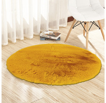 Tapis rond jaune en fausse fourrure sur parquet à côté d''une chaise