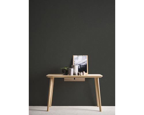 Schreibtisch aus Holz mit Dekoration und Accessoires an einer dunklen Wand